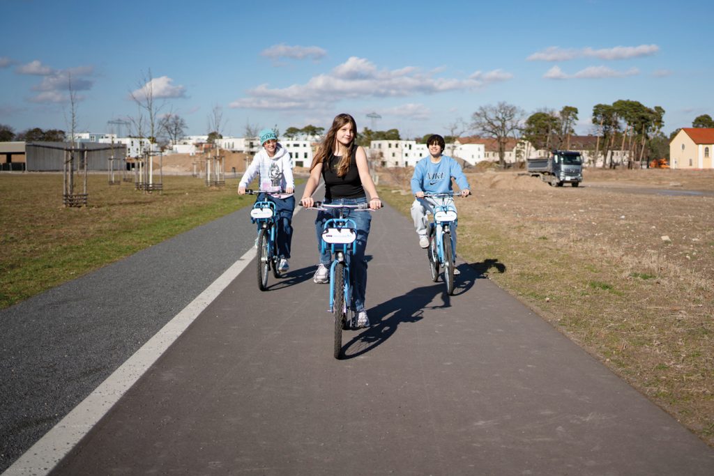 Drei Jugendliche die jeweils mit einem Nextbike auf den Betrachter zufahren.