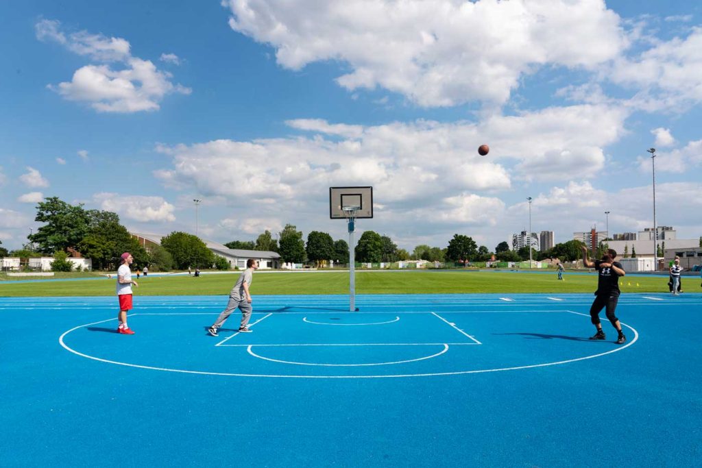 Drei Männer spielen Basketball auf der FRANKLIN Sportanlage