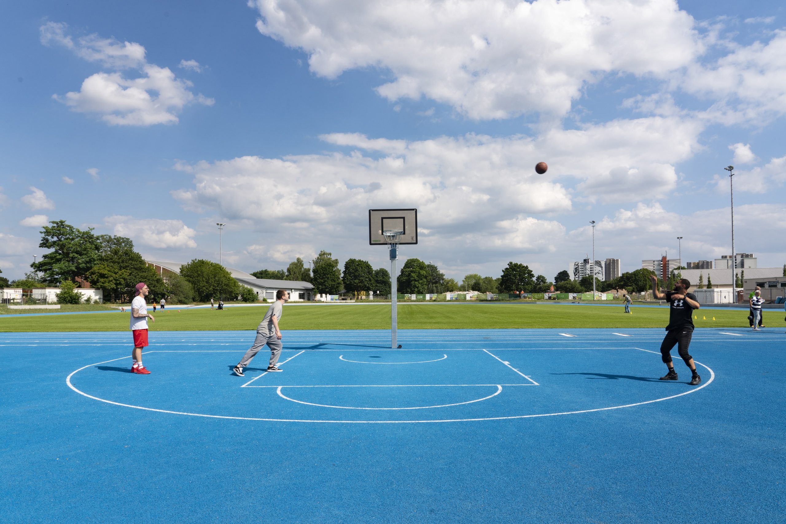 Drei Männer spielen Basketball auf der FRANKLIN Sportanlage