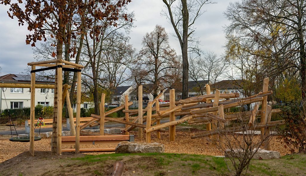 Spielplatz für Kinder ab sechs Jahren in der nördlichen Offizierssiedlung mit Holzkletterstruktur und Nestschaukel