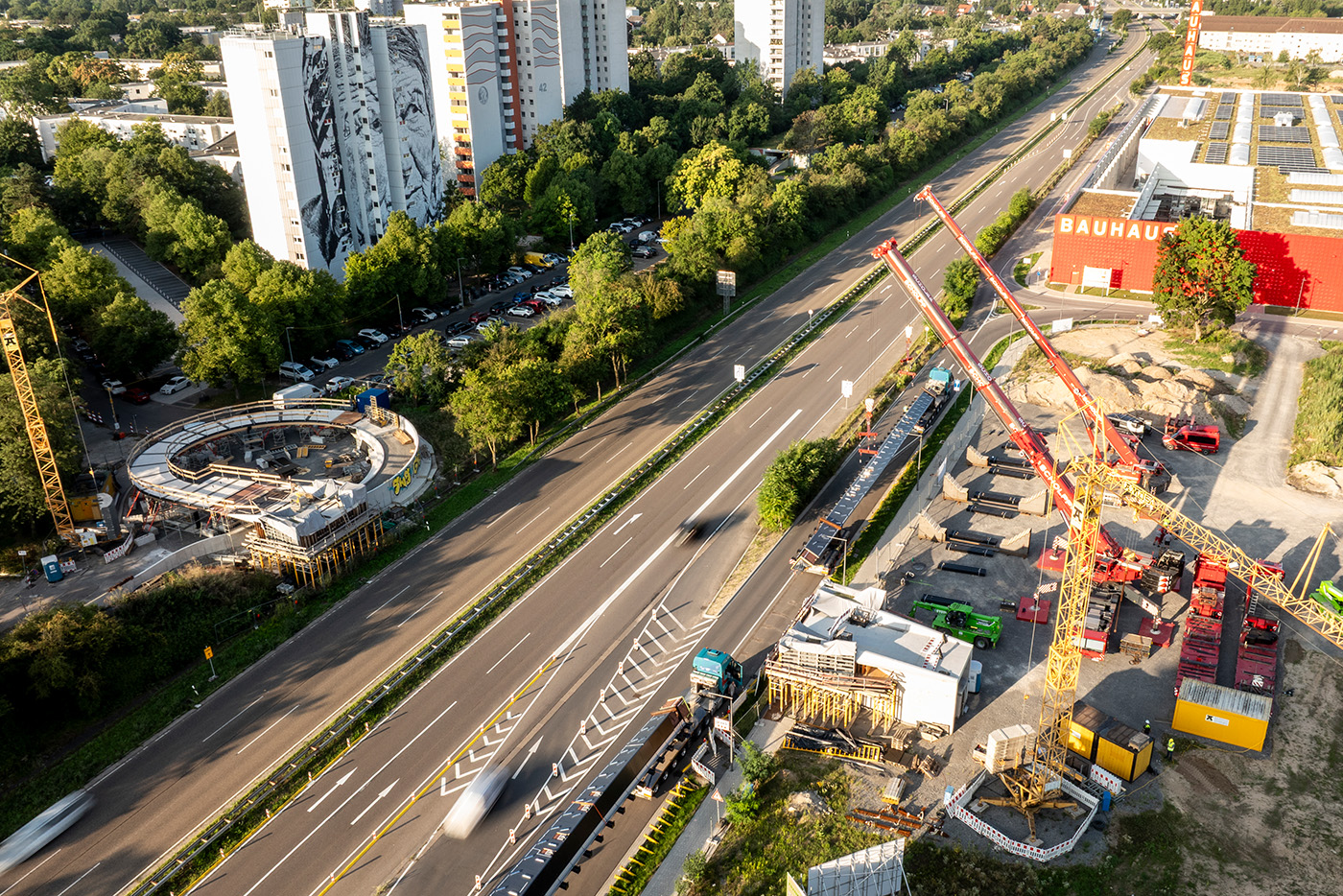 Drohnenaufnahme mit Blick auf die Bundesstraße 38 und die Baustelle des FRANKLIN Stegs. Im Hintergrund sind drei Hochhäuser des Stadtteils Vogelstand sichtbar.